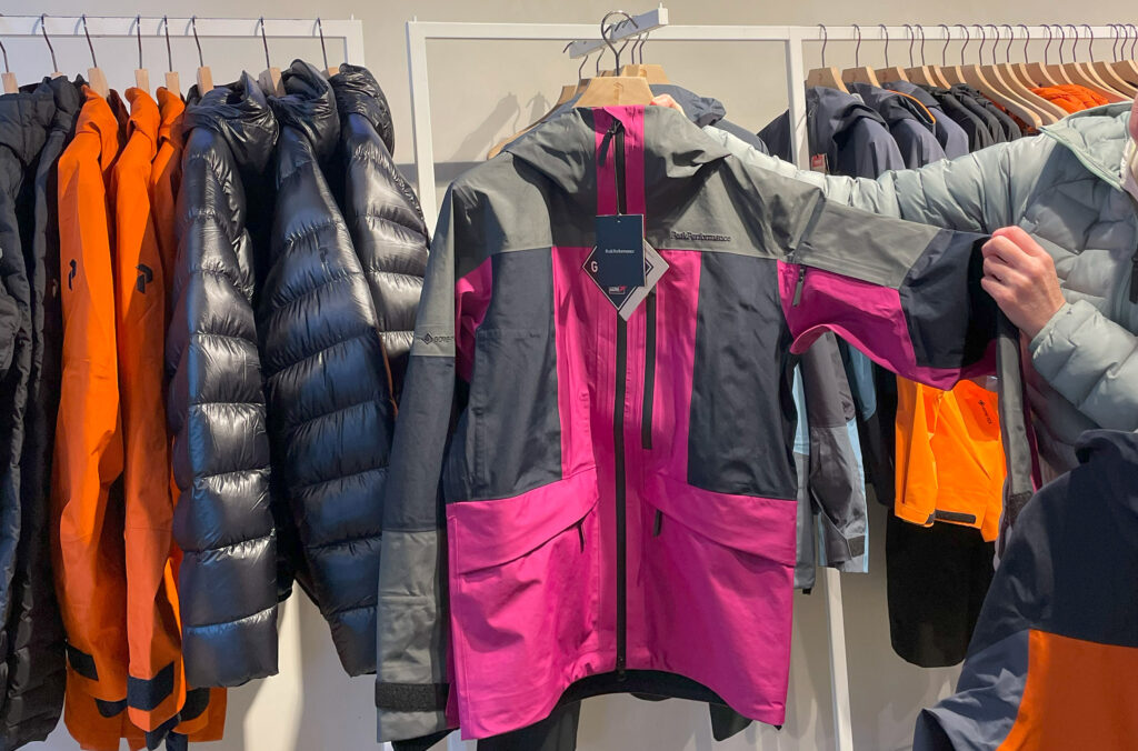 Create an image of a diverse group of adventurers exploring a picturesque outdoor setting, wearing ethically sourced outdoor clothing. Highlight eco-friendly materials like organic cotton, recycled fa