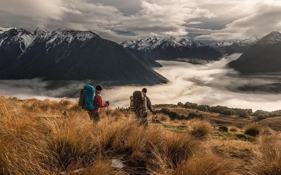 Create an image depicting modern sustainable outdoor apparel in a stunning natural setting. Show diverse individuals hiking through a lush forest, dressed in stylish, eco-friendly clothing made from r